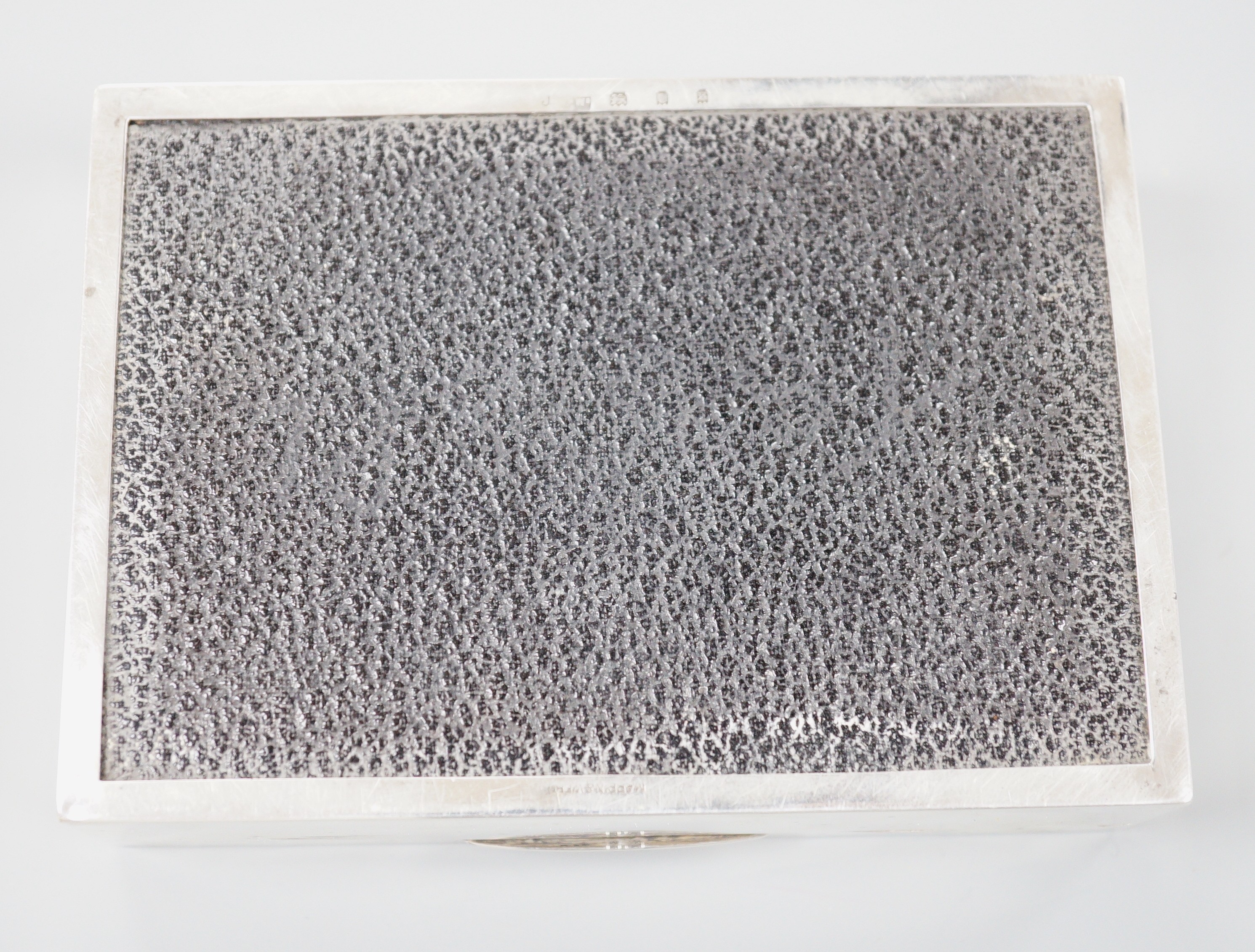A George V engine turned silver rectangular cigarette box, Mappin & Webb, London, 1933, 12.8cm.